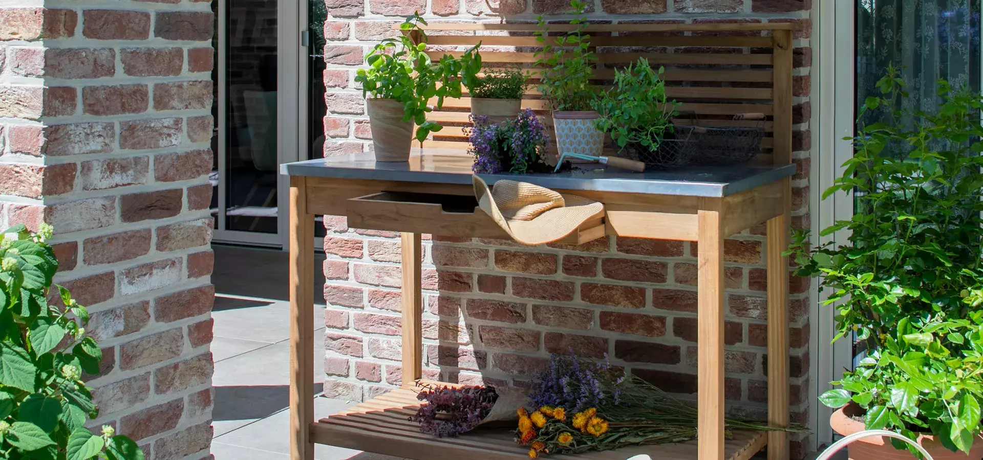 Teakholz Pflanztisch auf Terrasse mit Grünpflanzen drauf